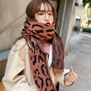 Close-up of thick leopard print knitted scarf with warm brown and black texture