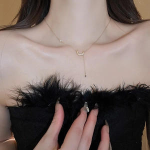 Détail d'un collier pendentif lune et étoile doré porté au cou d'un mannequin féminin