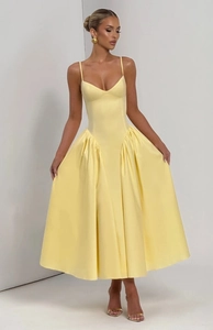 Détail du corsage plissé jaune et de la jupe trapèze fluide de cette robe élégante