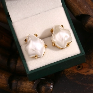 Detailed close-up of Baroque pearl earrings with 18K gold plating on green jewelry box