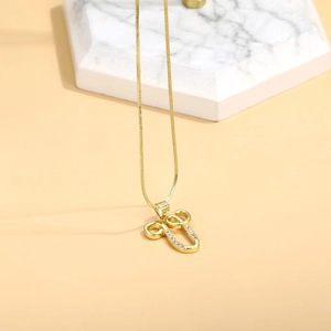 Macro detail of gold stethoscope pendant with sparkling zircons on elegant marble display
