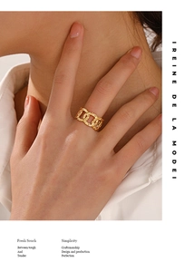 Macro detail of gold-plated chain link ring with hammered texture worn by a model