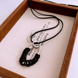 Détail du collier vintage goutte d'eau avec pendentif argenté et cordon noir tressé élégant