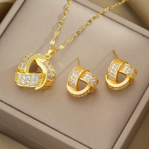 Detailed view of a gold jewelry set with geometric triangle pendants and white zircons