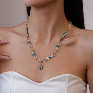 Détail du collier de perles ethnique avec cordelette bleu jaune et pendentif soleil argent