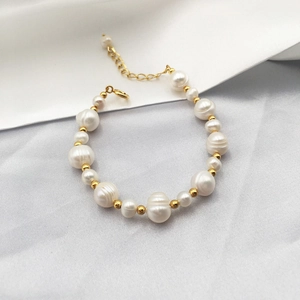 Baroque freshwater pearl bracelet with gold-plated beads and lobster clasp on silk fabric