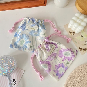 Détail de pochettes de rangement à cordon à motifs floraux bleus et violets et cordons roses