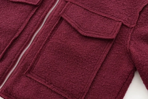 Détails de la veste en laine bordeaux montrant le zip en métal et la poche rabat