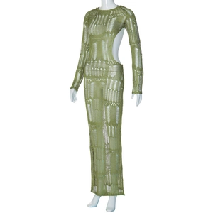 Close-up of green knit maxi dress featuring intricate side cut-outs and sheer texture