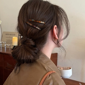 French retro tortoiseshell hair clips set in amber brown acetate on model's hair