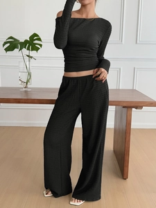 Close-up of black textured fabric on long-sleeve top and wide-leg pants two-piece set