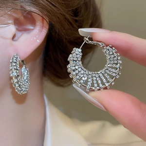 Close-up of elegant silver hoop earrings with sparkling rhinestones and hollow design