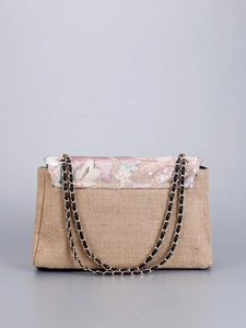 Detail of floral embroidery and sequins on linen shoulder bag with chain strap