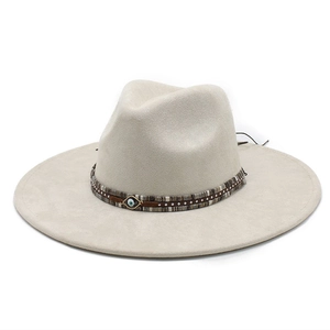 Detail of cream felt fedora hat featuring a woven band with a blue evil eye charm