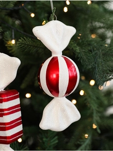 Detail of red and white striped candy ornament with glitter on a Christmas tree