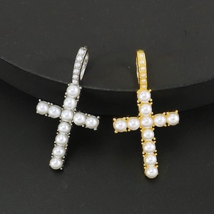 Gold and silver cross pendants with pearls on a black display stand, tennis chain style