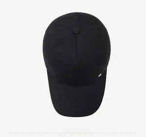Top view of a black winter baseball cap with thick twill texture and metal badge detail