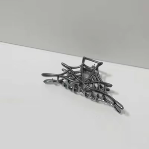 Detailed view of gunmetal spider web metal hair claw with sleek punk aesthetic design