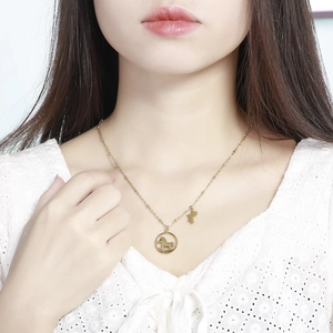 Collier en acier titane doré avec pendentif poney évidé porté par un mannequin
