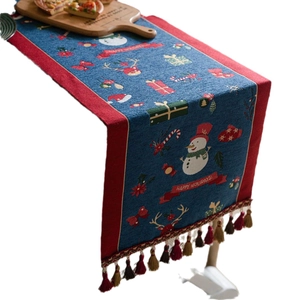 Blue Christmas table runner with snowman patterns, red borders and decorative tassels