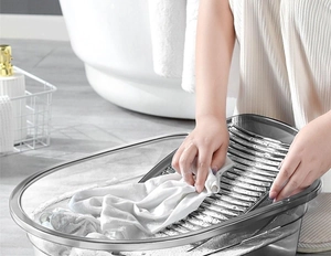 Close-up of transparent laundry tub with integrated washboard for manual clothes washing