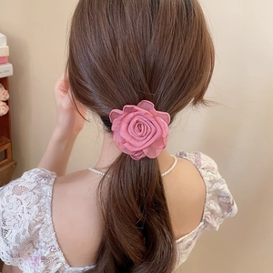 Detail eines rosa Chiffon-Blumen-Haargummis für einen eleganten Look am Pferdeschwanz