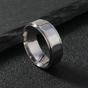 Modern 8mm stainless steel ring with faceted geometric design on a dark stone background