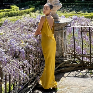 Détail de la robe longue en satin jaune gingembre avec dos nu élégant et fini soyeux