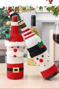 Macro detail of knitted Santa and Snowman wine bottle covers for Christmas table decor