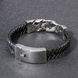 Detail of black braided leather men's bracelet with polished silver steel chain links