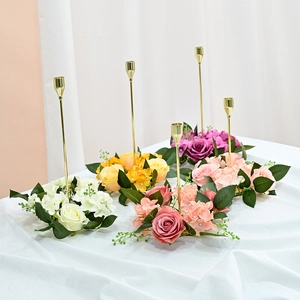 Detail of elegant gold candle holders with colorful artificial rose and hydrangea floral rings