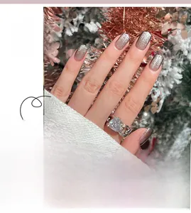 Detail of aurora cat eye press-on nails with silver glitter finish and festive holiday theme