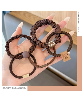 Detail of 5-piece brown hair tie set featuring velvet scrunchies and heart charms