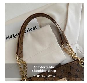 Macro shot of vintage tote bag with retro monogram pattern and gold chain strap detail