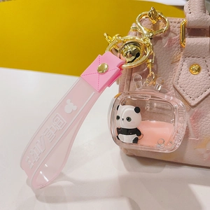 Detail of pink silicone strap and acrylic panda keychain with bear 3 text and golden bell