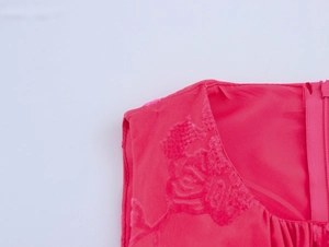 Détail macro de la robe rose fuchsia avec tissu floral texturé et fermeture éclair invisible
