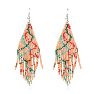 Close-up of handmade beaded tassel earrings with bohemian Christmas tree geometric patterns