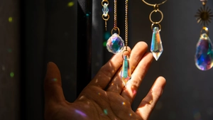 Close-up of brass suncatcher showing crystal prism rainbows and golden sun pendant details