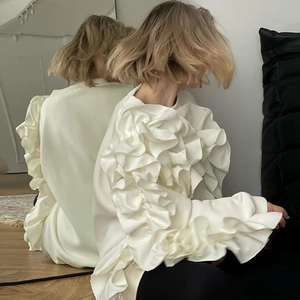 Détail du sweat-shirt blanc à manches longues avec volants 3D denses et texture satinée
