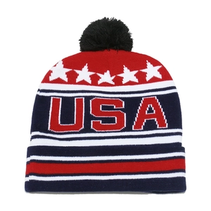 Knitted USA flag beanie with a black pompom, featuring white stars and red stripes