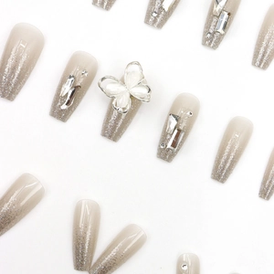 Sparkling nude gradient long press-on nails with silver butterfly and rhinestone accents