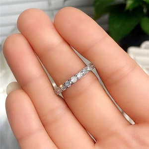 Nahaufnahme eines silbernen Eternity-Rings mit rundgeschliffenen Zirkonia am Finger