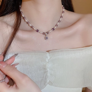 Close-up of pearl and purple beaded necklace with square zirconia pendant on model