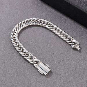 Detailed close-up of a silver stainless steel Cuban link bracelet with a box clasp