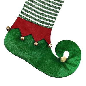 Close-up of green velvet Christmas elf stocking with red trim and gold bells detail