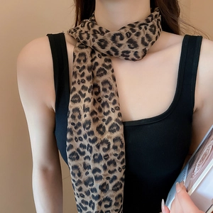 Detail of leopard print silk scarf tied casually around a model's neck for a retro style