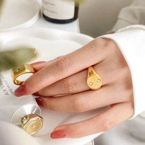 Macro detail of gold signet rings with star engraving and three-diamond inlay setting