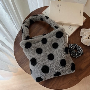 Gros plan détaillé du mini sac en peluche à pois avec une texture douce et veloutée