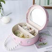 Pink round jewelry box with pearl handle and inner mirror for travel storage