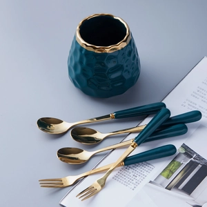 Luxury dark green ceramic storage jar with gold-rimmed stainless steel forks and spoons